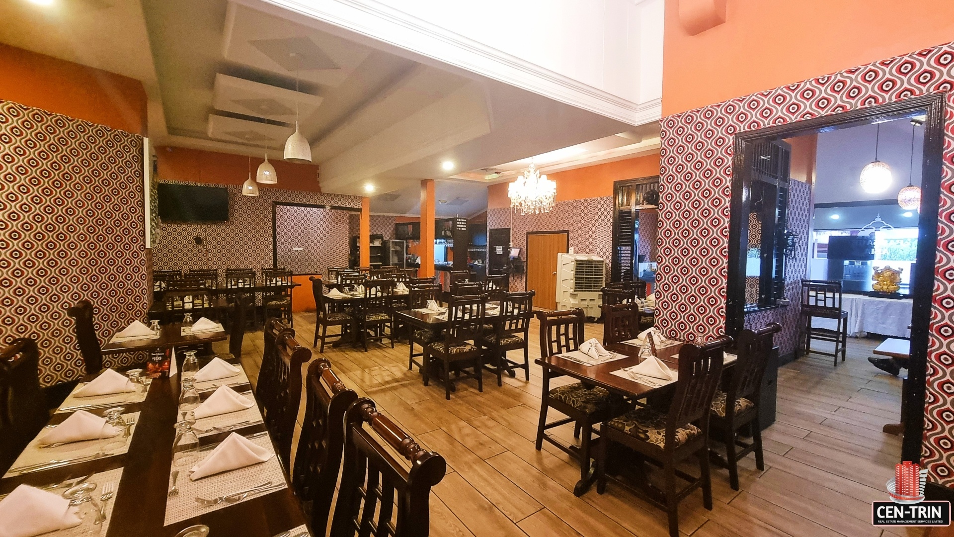 Bright orange restaurant interior with tables, chairs, and a chandelier. "Prime Restaurant Space"