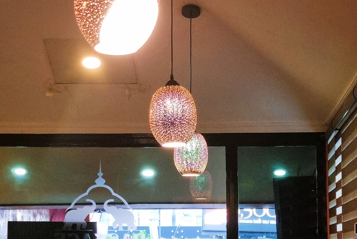 Three pendant lights with colorful glass shades hanging from a white ceiling. "Prime Restaurant Space"