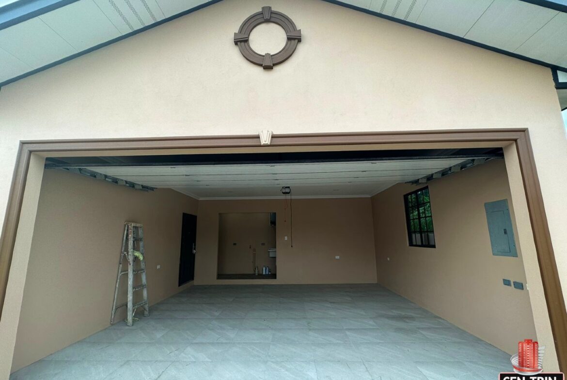 Open garage door with a metal ladder leaning against it, revealing a glimpse of the garage interior