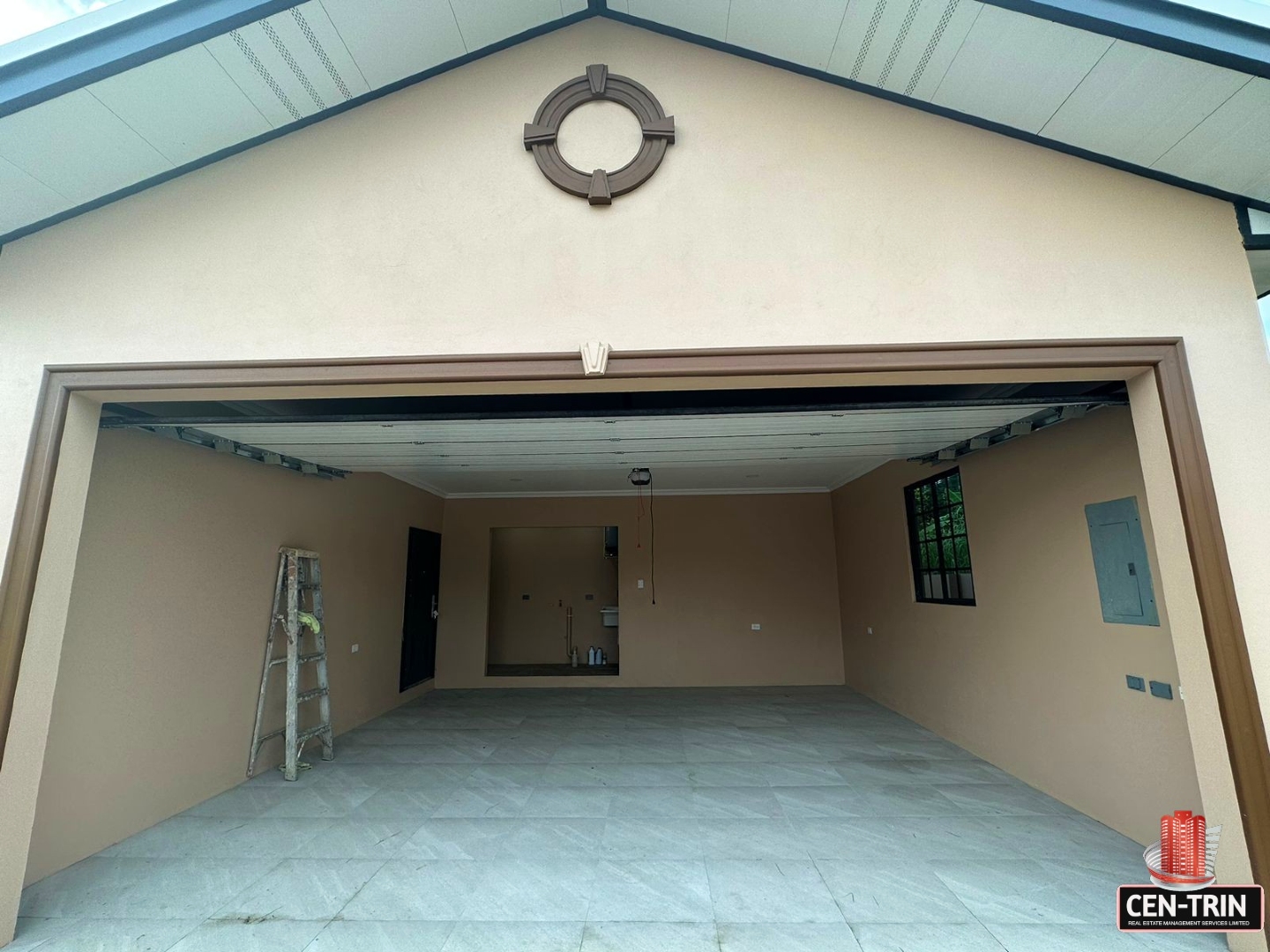 Open garage door with a metal ladder leaning against it, revealing a glimpse of the garage interior