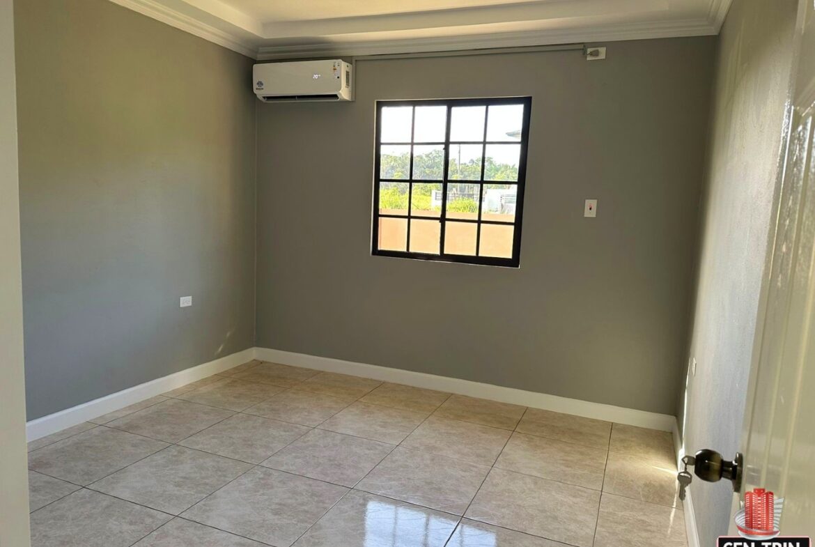 Bright bedroom with a large window, tiled floors.