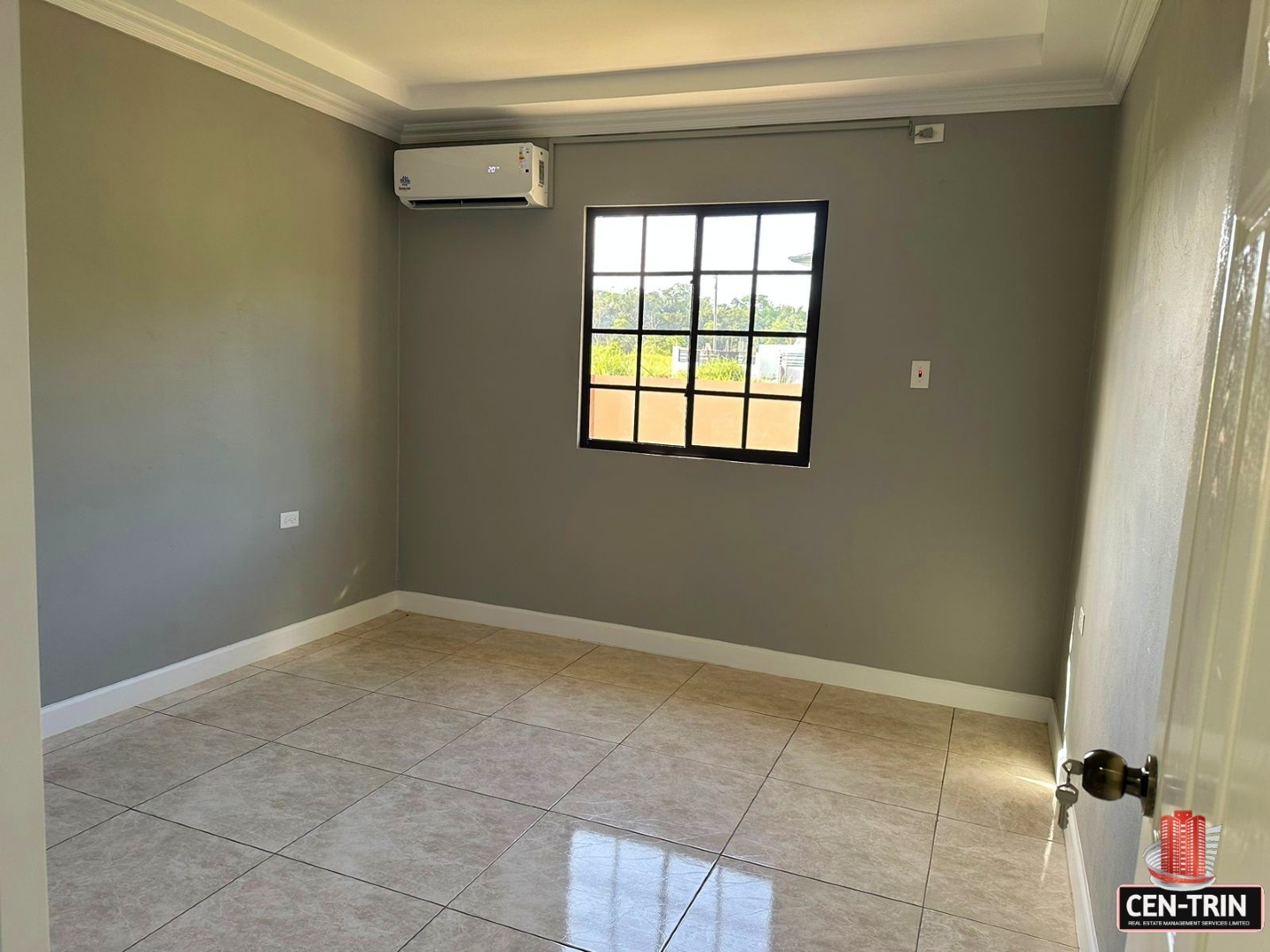 Bright bedroom with a large window, tiled floors.