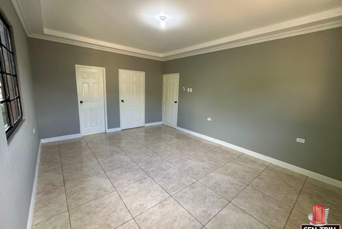 Master bedroom with enough space for a king-size bed, a walk-in closet, and a doorway leading to a bathroom.