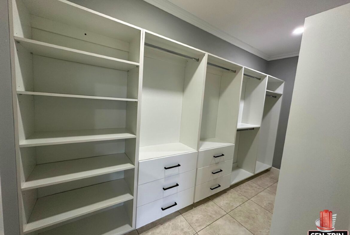 Organized walk-in closet with shelves, drawers, and hanging rods