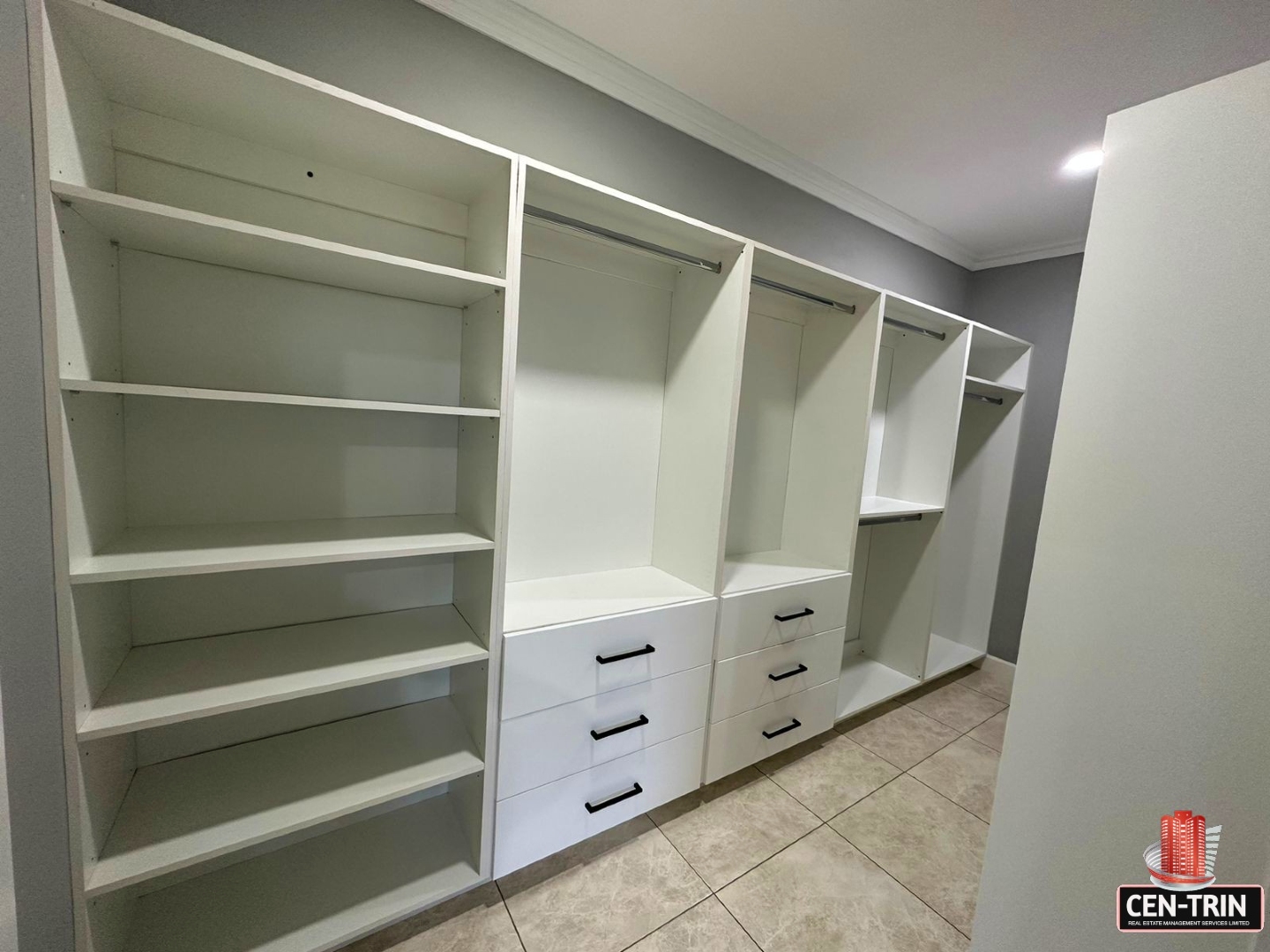 Organized walk-in closet with shelves, drawers, and hanging rods