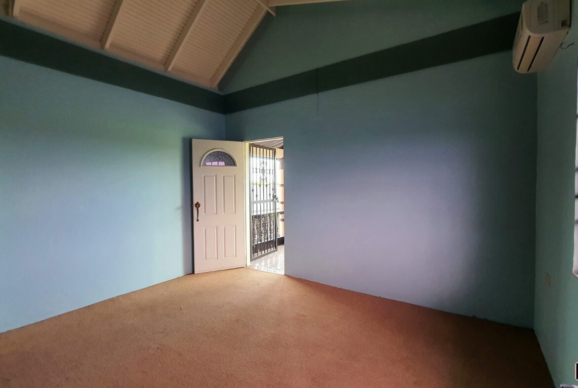 An empty room with a closed door and windows.