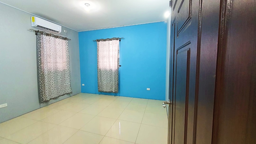 Spacious living area with comfortable furniture in Chaguanas gated apartment (Cen-Trin Real Estate)