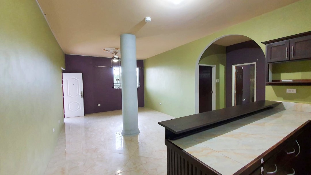 Spacious living area with comfortable furniture in Chaguanas gated apartment (Cen-Trin Real Estate)