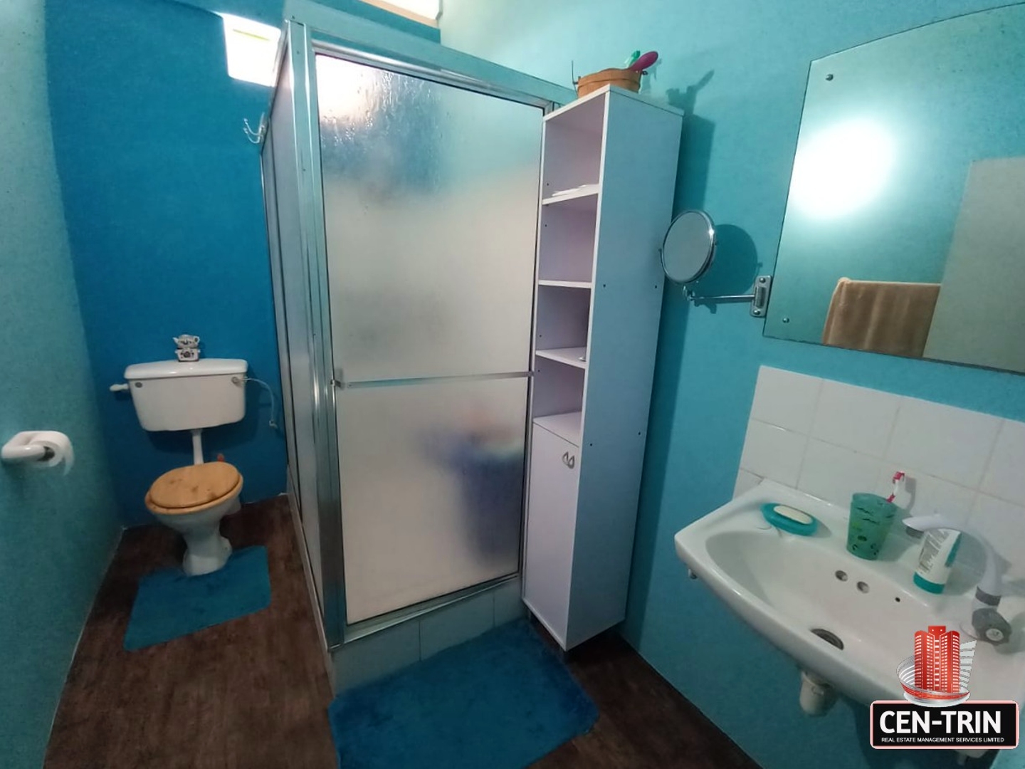 A bathroom with a toilet, sink with faucet, and a shower with a glass door.