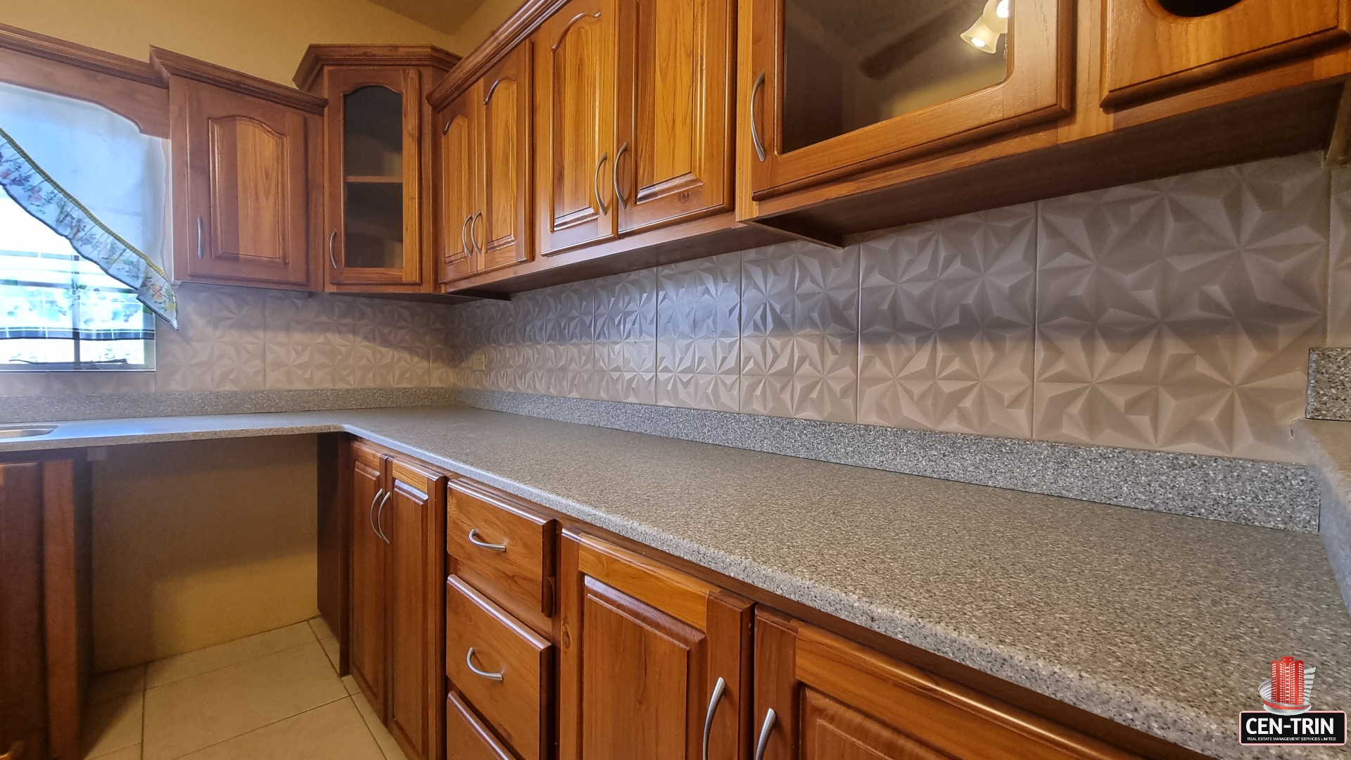 Kitchen counter with gray countertops and stainless steel sink in townhouse for sale.