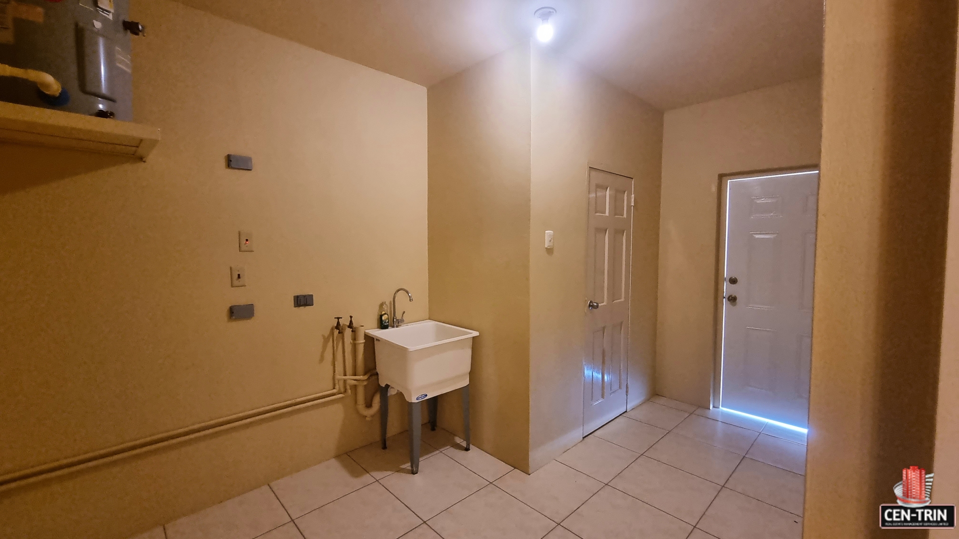 Laundry room in townhouse for sale with sink, faucet, cabinets, and washer and dryer.