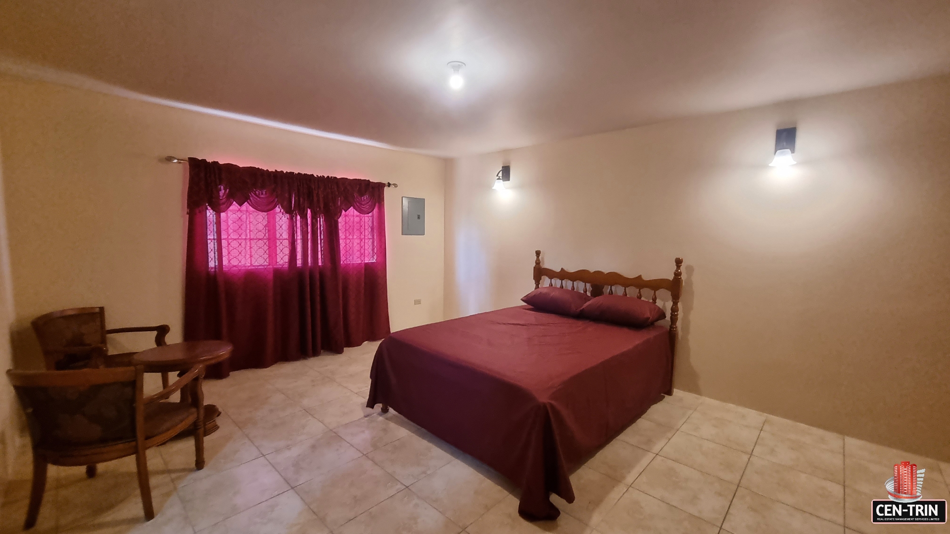Master bedroom in townhouse for sale with a king-size bed, dresser, mirror, two windows, and a carpeted floor.