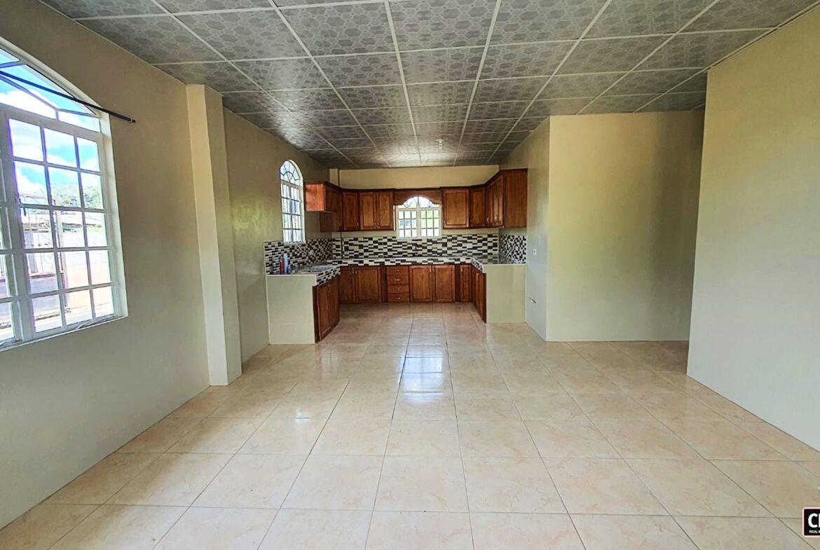 Empty kitchen with wooden cabinets and tiled floor
