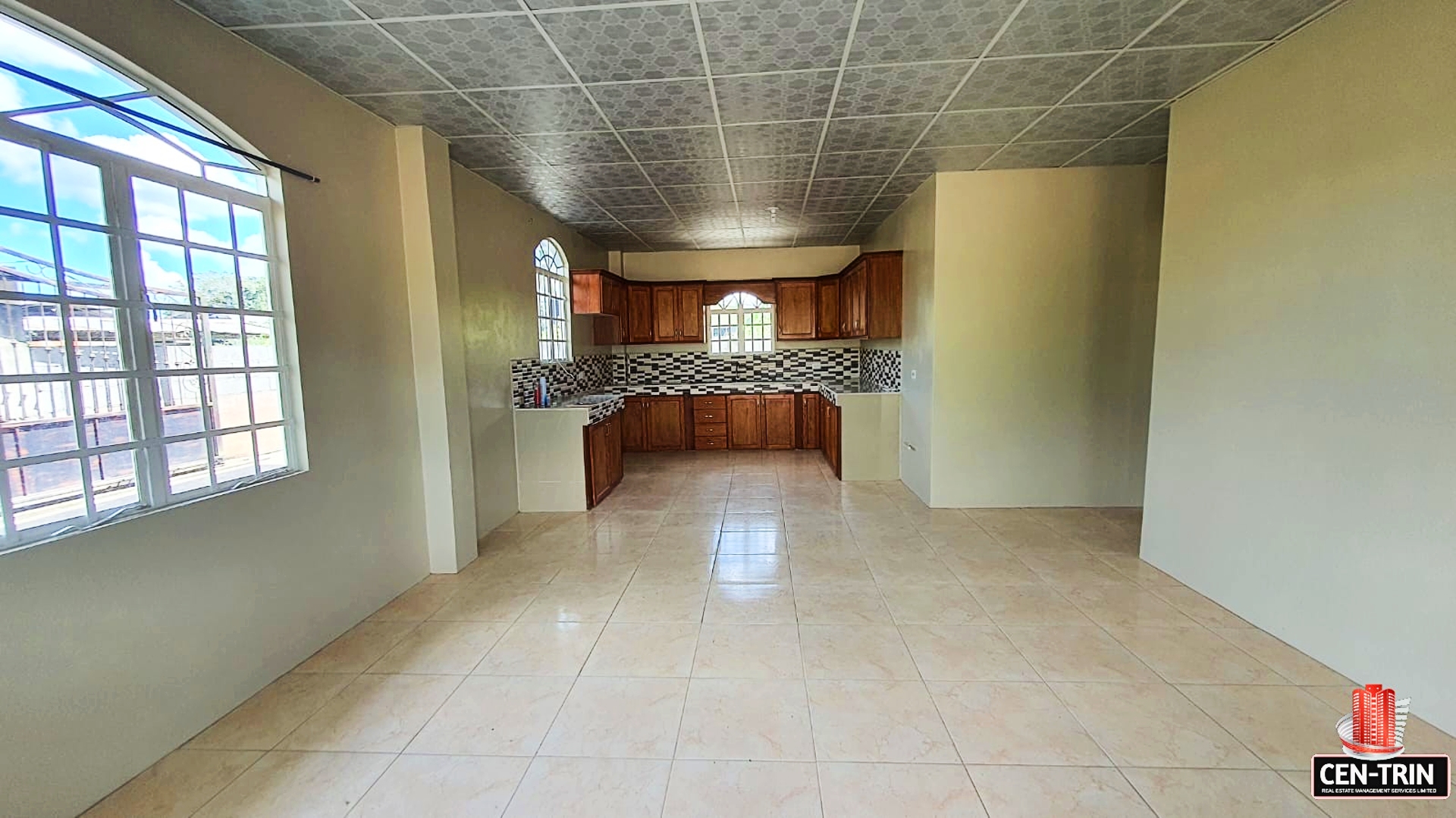Empty kitchen with wooden cabinets and tiled floor