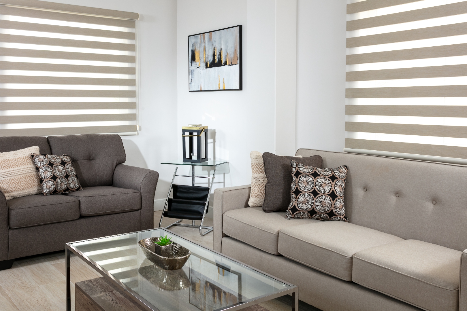 Bright and airy living room interior at Roystonia Mews, featuring modern furniture, neutral tones, and large windows with blinds.